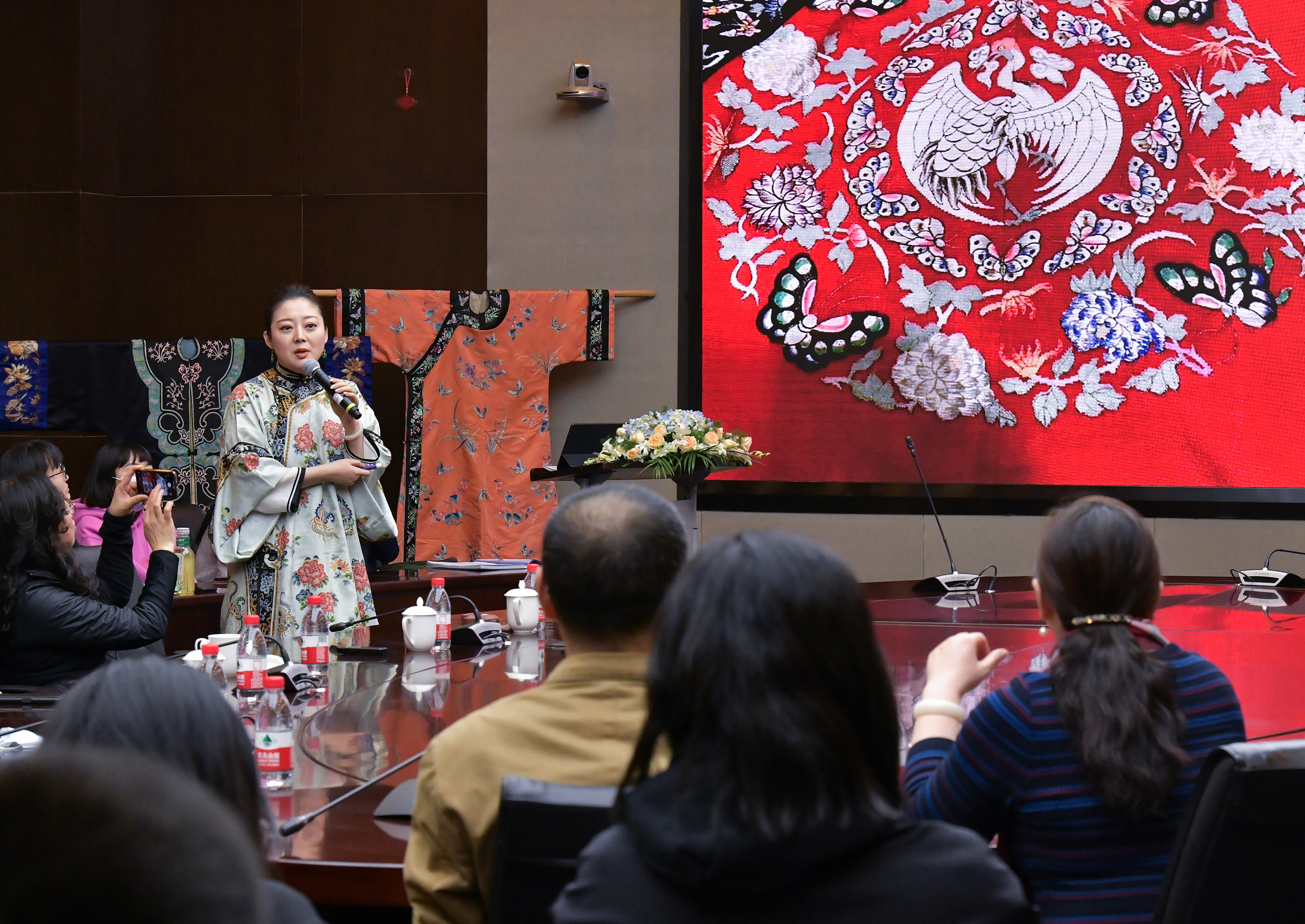 3月30日,毕红(左一)向学生介绍传统服饰知识.